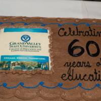 A cake with chocolate frosting with the words "Celebrating 60 years of education!"